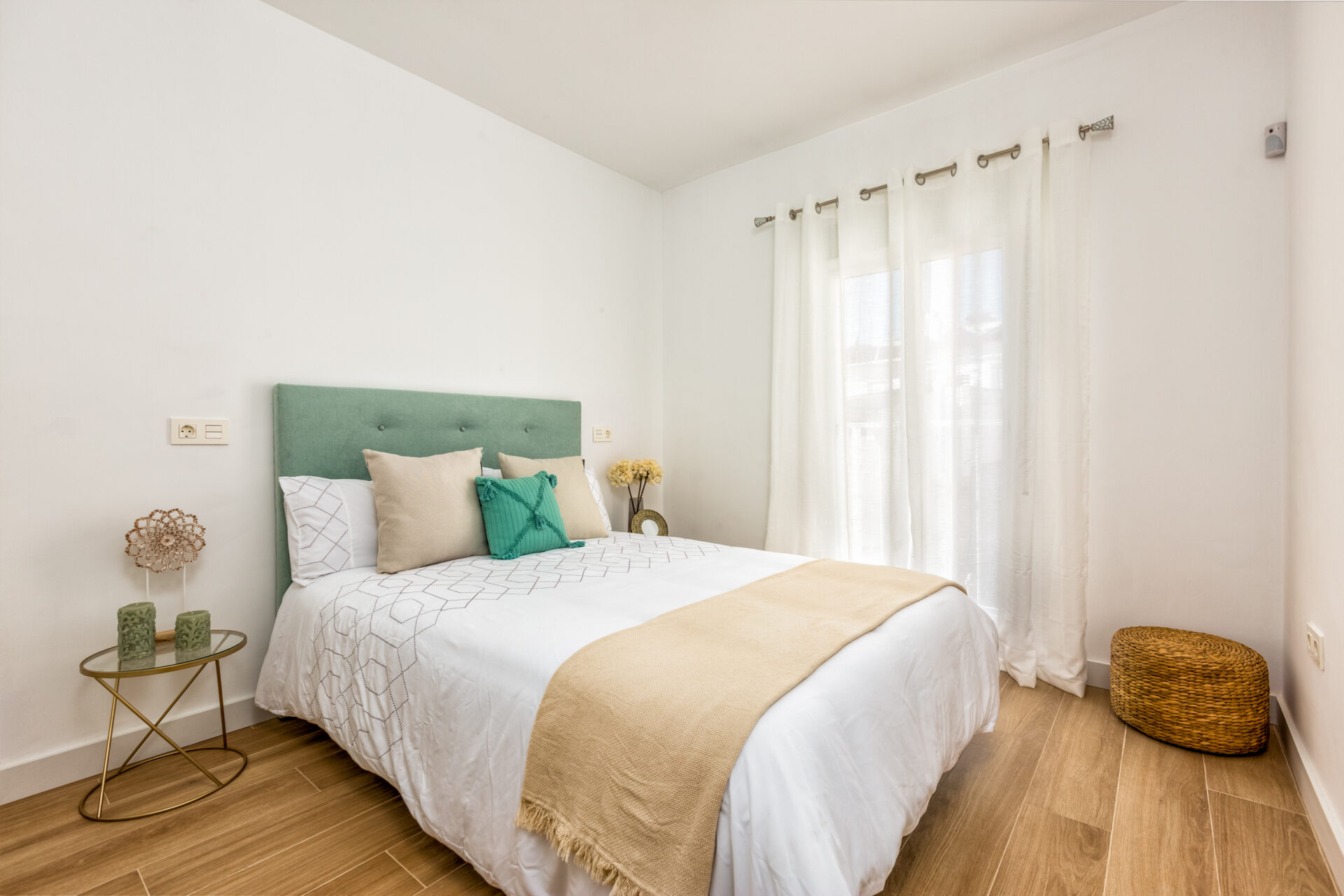 Sorolla 36: dormitorio con cabecero verde y ventana con cortinas blancas